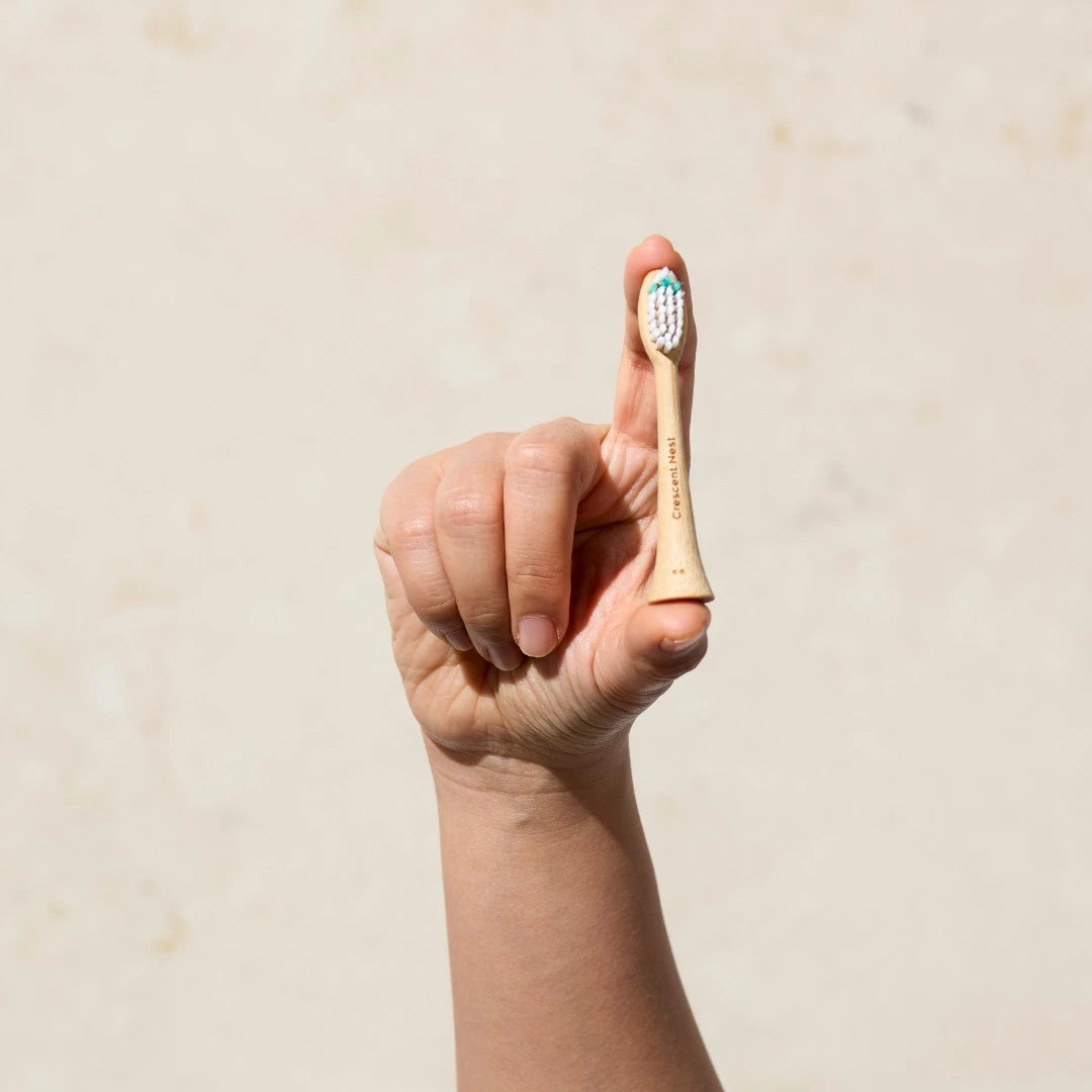 Hand holding a toothbrush with a plain background