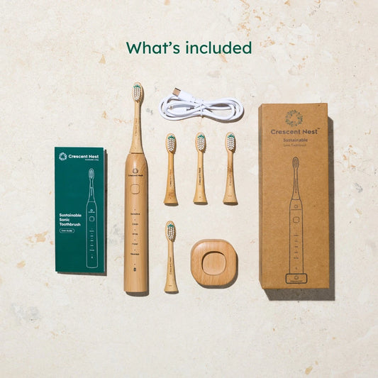 Set of bamboo electric toothbrushes with packaging and accessories on a light background