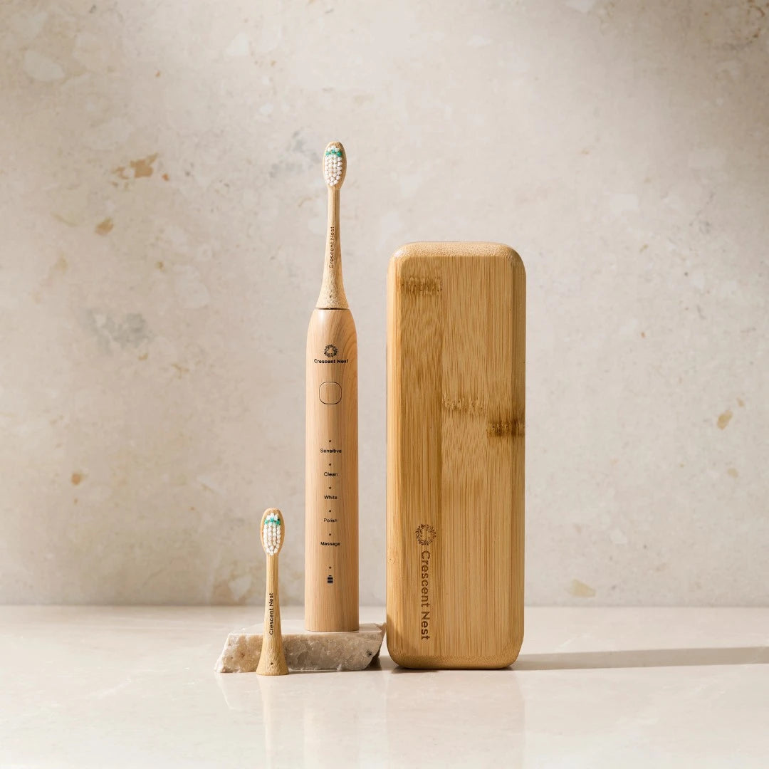 Bamboo electric toothbrush and charging case on a neutral background