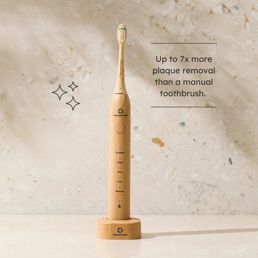 Wooden electric toothbrush on a textured beige background with text about plaque removal.