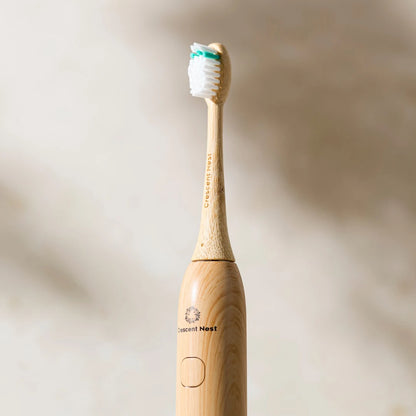 Wooden electric toothbrush with white bristles on a beige background