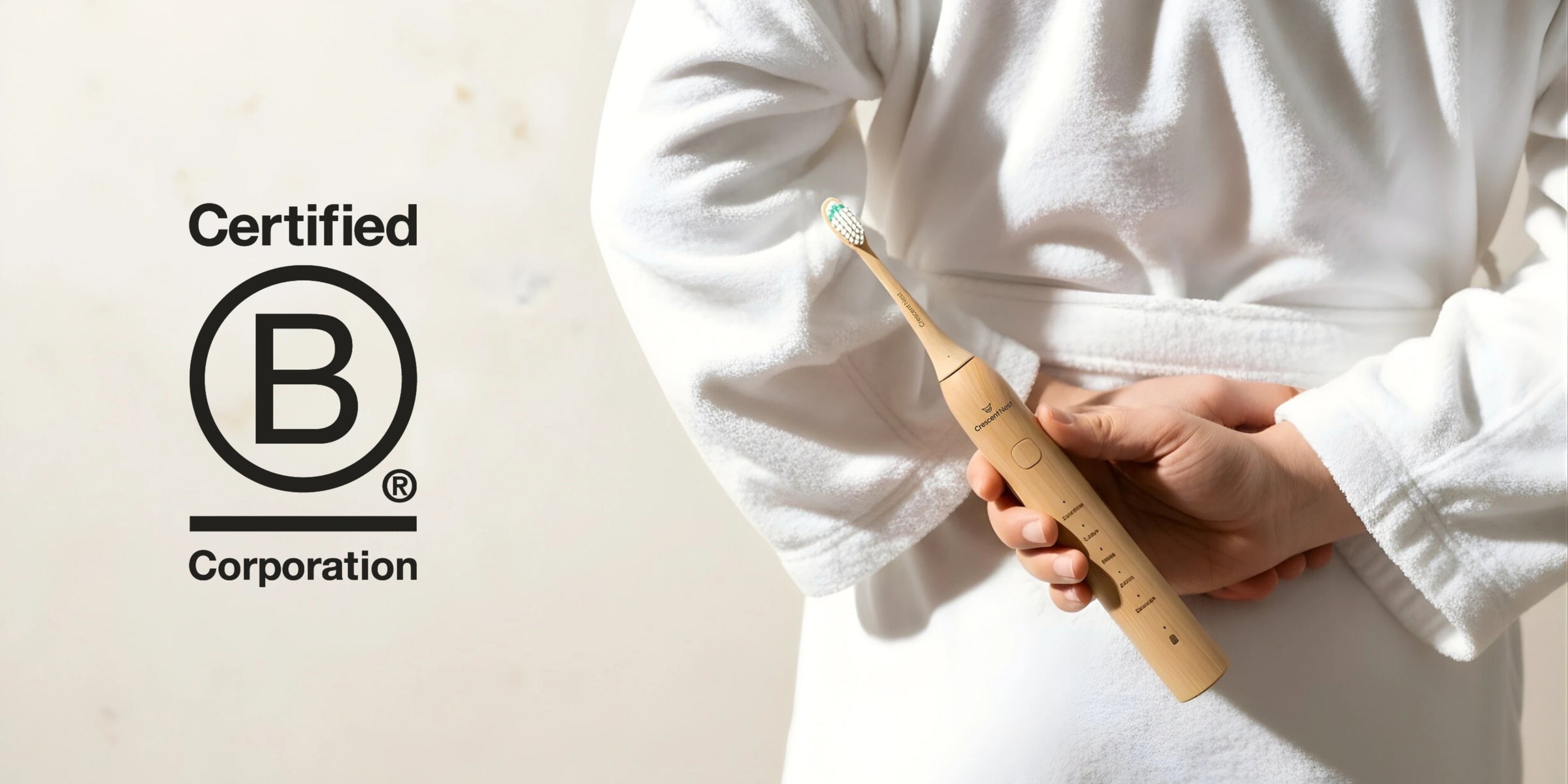 Person holding a crescent nest bamboo electric toothbrush with a Certified B Corporation logo in the corner.