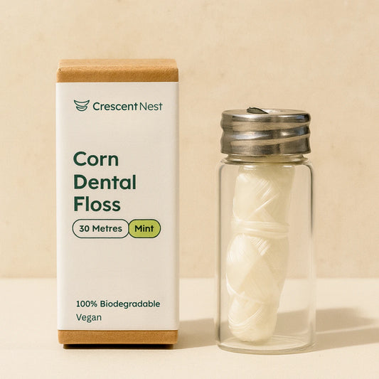 Crescent Nest corn dental floss packaging with a glass container on a beige background