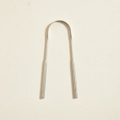 Crescent nest tongue scraper Medical Grade 304 on a creamy background