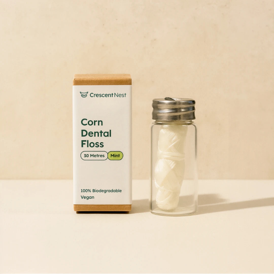 Crescent Nest corn dental floss packaging with a glass container on a beige background