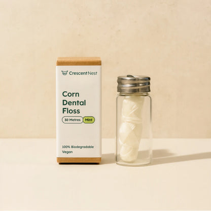 Crescent Nest corn dental floss packaging with a glass container on a beige background