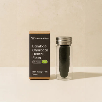 Bamboo charcoal dental floss with packaging on a beige background