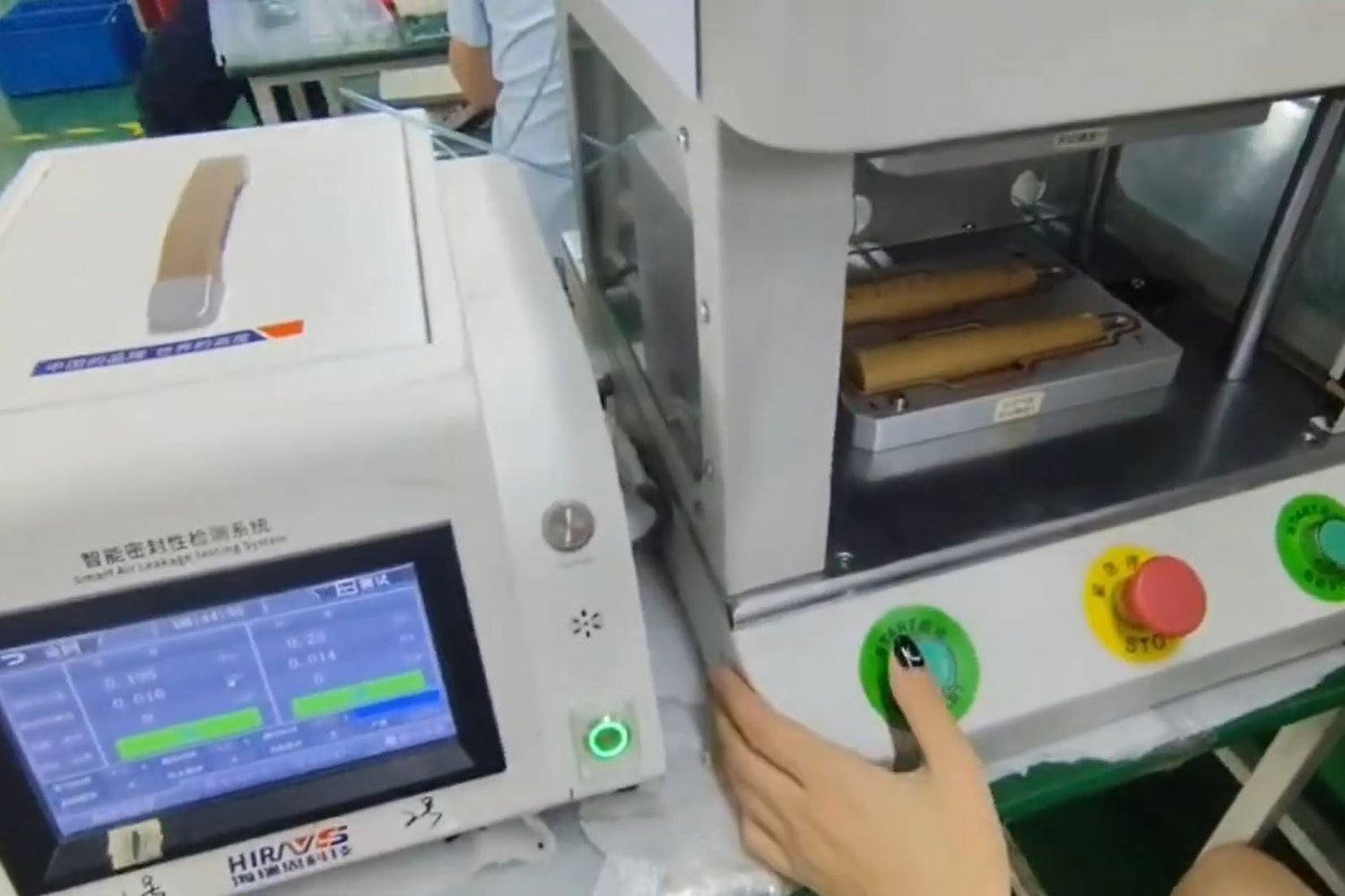 Person operating Electric toothbrush manufacturing equipment with digital display and control buttons.