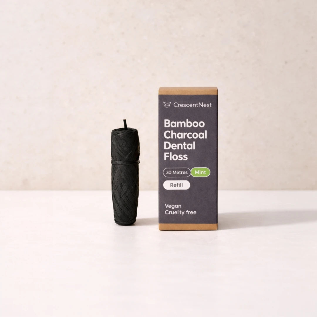 Black bamboo charcoal dental floss refill and its packaging on a beige background