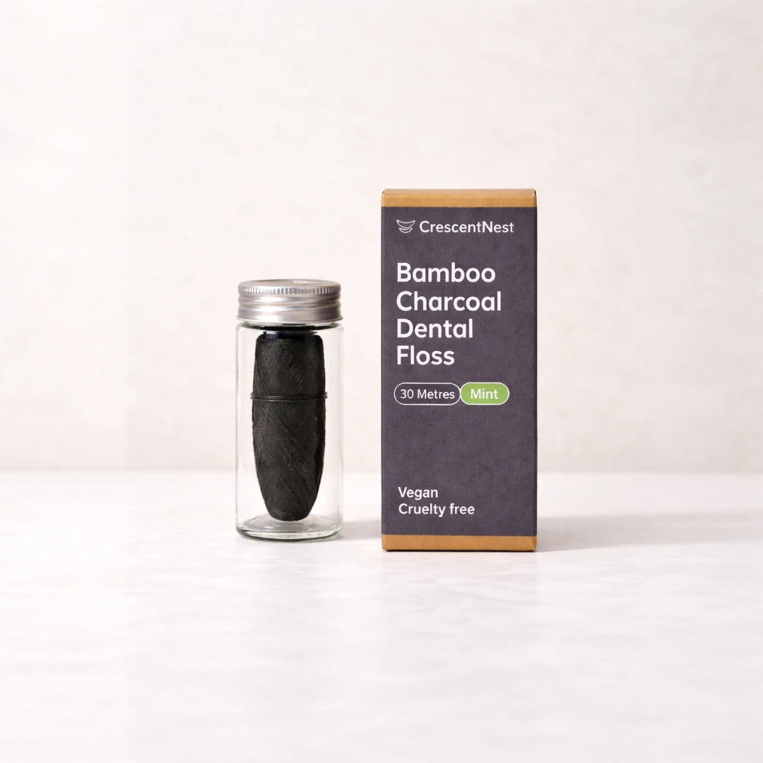 Bamboo charcoal dental floss in a clear container with packaging on a white background
