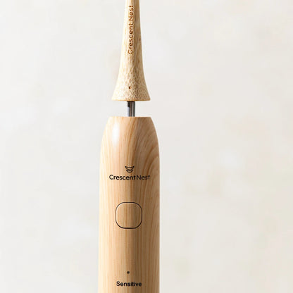 Close-up of the Crescent Nest bamboo electric toothbrush showing the detachable brush head and connection point.