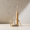 Crescent Nest bamboo electric toothbrush displayed with multiple replacement bamboo brush heads on a bathroom surface.