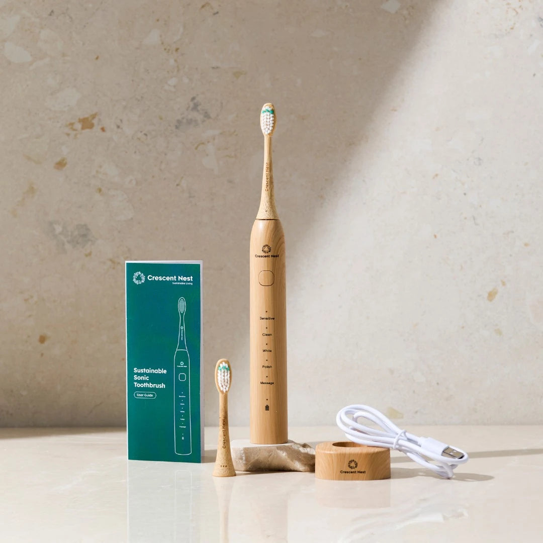 Wooden electric toothbrush with packaging and charging cable on a neutral background