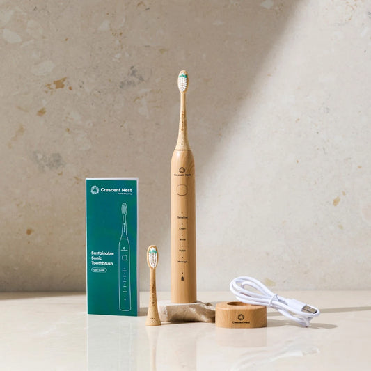Wooden electric toothbrush with packaging and charging cable on a neutral background