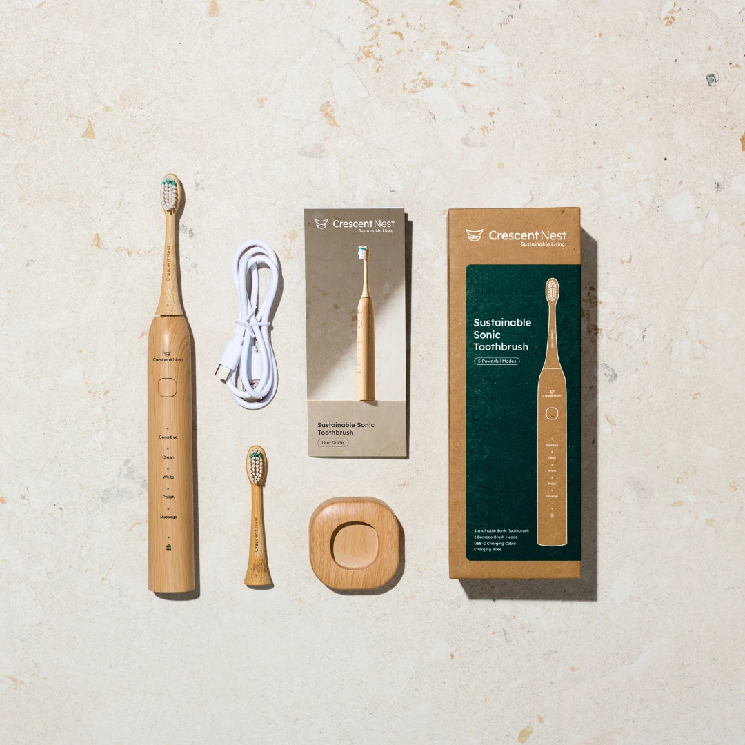 Crescent Nest Sustainable Sonic Toothbrush full set including bamboo toothbrush handle, brush heads, charging base, USB-C cable, and packaging.