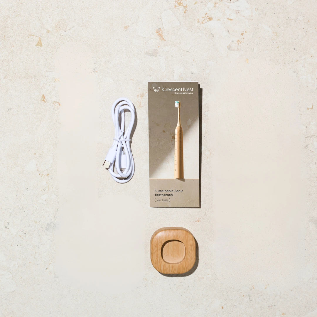 Crescent Nest Sustainable Sonic Toothbrush accessories including USB-C charging cable, user guide, and bamboo charging base.