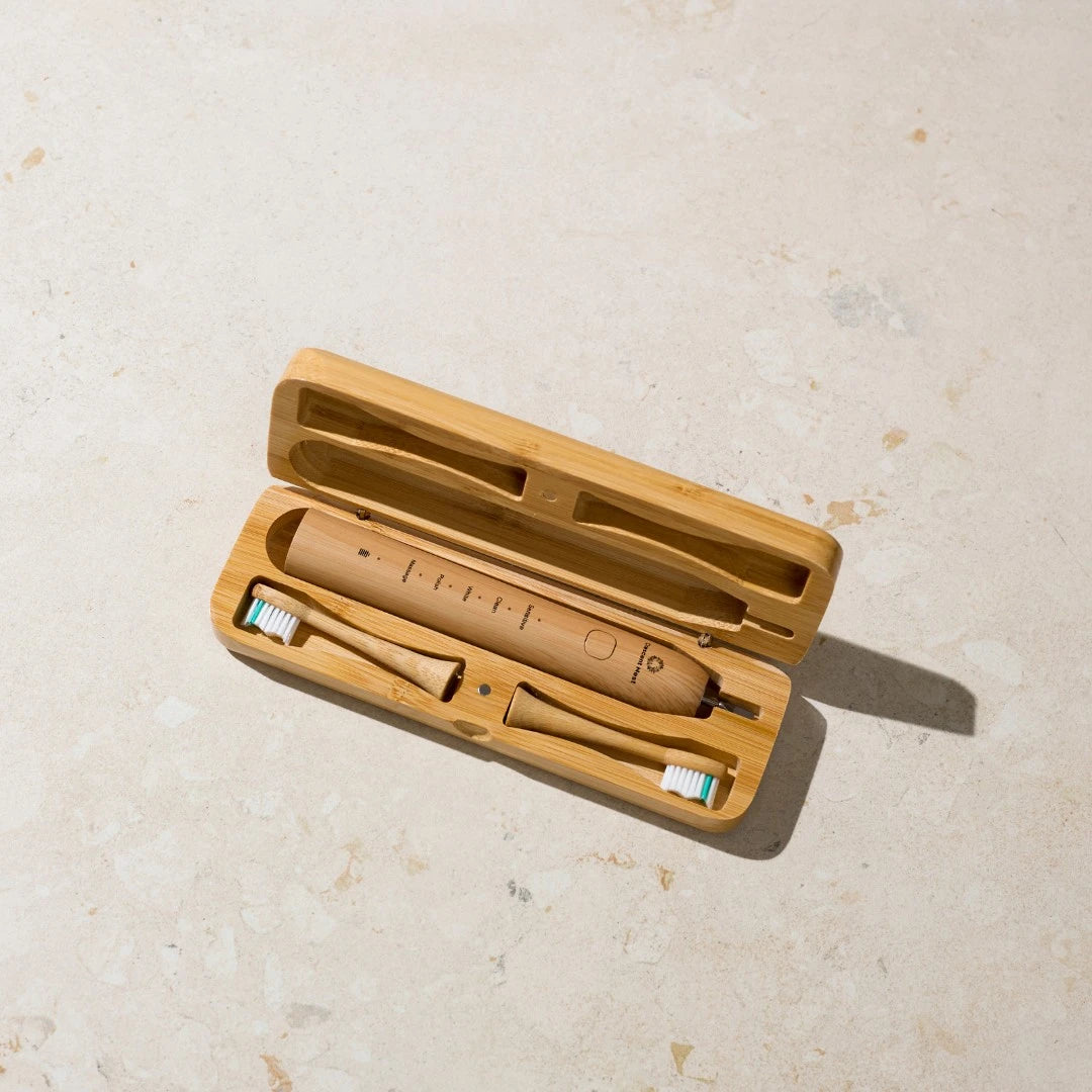 Wooden electric toothbrush with travel case on a light beige surface